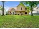Expansive backyard with lush green lawn, mature trees and a charming two-story home at 1086 Erie Cir, Stone Mountain, GA 30087