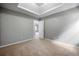 Bedroom with trey ceilings and neutral paint; a doorway view of another room at 1086 Erie Cir, Stone Mountain, GA 30087