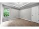 This bedroom includes neutral carpet, gray walls and a tray ceiling at 1086 Erie Cir, Stone Mountain, GA 30087
