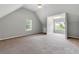 Spacious carpeted bedroom boasts a large window, vaulted ceilings, and natural light at 1086 Erie Cir, Stone Mountain, GA 30087
