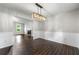 Elegant dining room with stylish light fixture and wood-look tile floors at 1086 Erie Cir, Stone Mountain, GA 30087