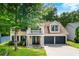 Charming two-story home boasts a welcoming front porch, two-car garage, and lush landscaping, perfect for curb appeal at 1086 Erie Cir, Stone Mountain, GA 30087