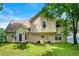 Back exterior view of a two-story home showcasing a large yard and mature trees at 1086 Erie Cir, Stone Mountain, GA 30087