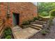 The exterior of the home features a brick wall, a door, steps, and landscaping with plants and mulch at 2892 Guinevere Ne Dr, Atlanta, GA 30345