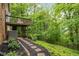Exterior side yard with brick, AC unit, wooden deck, and stone path at 2892 Guinevere Ne Dr, Atlanta, GA 30345