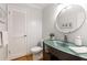 Half bath with a unique vessel sink, round mirror, and updated lighting and fixtures at 2892 Guinevere Ne Dr, Atlanta, GA 30345