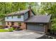 Exterior view of home, featuring brick facade, siding, attached garage, and mature trees at 2892 Guinevere Ne Dr, Atlanta, GA 30345