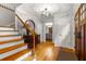 Inviting foyer with hardwood floors, stairs with iron railings, and a decorative table under a modern chandelier at 2892 Guinevere Ne Dr, Atlanta, GA 30345