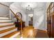 Light filled foyer features hardwood floors, staircase, decorative lighting, and entry to living area at 2892 Guinevere Ne Dr, Atlanta, GA 30345