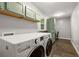 Well-lit laundry room featuring a washer, dryer, and overhead cabinets at 2892 Guinevere Ne Dr, Atlanta, GA 30345