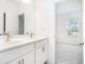 A bright bathroom featuring double sinks and a view into an adjacent room filled with light at 3514 Ambassador Aly, Scottdale, GA 30079