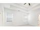 Well-lit bedroom featuring a tray ceiling, ceiling fan, and neutral walls at 3514 Ambassador Aly, Scottdale, GA 30079