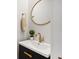 Bathroom featuring a round mirror, a black vanity with gold hardware, and neutral paint at 560 Morgan Ne St, Atlanta, GA 30308