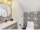 Bathroom features modern fixtures, unique black and white patterned tile backsplash, and a stylish round mirror at 560 Morgan Ne St, Atlanta, GA 30308