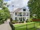 Beautiful two-story home with a black metal fence, lush greenery, and a long driveway at 560 Morgan Ne St, Atlanta, GA 30308