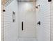 Modern bathroom shower featuring white subway tiles, glass door, bronze shower head, and unique patterned accent at 560 Morgan Ne St, Atlanta, GA 30308