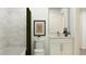 Cozy bathroom features a shower with green curtain, a toilet and vanity with a mirror and lighting at 811 Atkins Ln, Woodstock, GA 30188