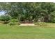 Landscaped backyard with a stone pathway, bench, swing, and lush greenery, perfect for relaxing at 105 Pine Valley Ct, Hiram, GA 30141