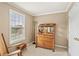 Well-lit bedroom with a window, antique dresser with mirror, rocking chair, and tan walls at 105 Pine Valley Ct, Hiram, GA 30141
