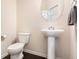 Powder room with pedestal sink, round mirror and tile flooring at 316 Sierra Ct, Mcdonough, GA 30253
