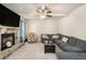 Cozy living room with a stone fireplace, plush seating, and a ceiling fan at 316 Sierra Ct, Mcdonough, GA 30253