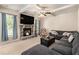 Cozy living room with a stone fireplace, plush seating, and a ceiling fan at 316 Sierra Ct, Mcdonough, GA 30253