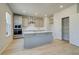 Bright kitchen features an island, stainless steel appliances, and gray cabinetry at 619 Leafy Branch Way, Mcdonough, GA 30253