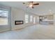 Bright living room featuring a modern fireplace, ceiling fan, and open layout flowing into a kitchen area at 619 Leafy Branch Way, Mcdonough, GA 30253
