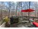 Outdoor deck featuring a grill, dining set, and wooded views, perfect for outdoor entertaining at 154 Hunters Trl, Dallas, GA 30157