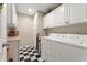 Functional laundry room with washer, dryer, and checkerboard floors at 154 Hunters Trl, Dallas, GA 30157