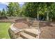 Inviting backyard featuring stone steps leading to a seating area, with wood mulch and mature trees and landscaping at 4320 Cody Ct, Cumming, GA 30040