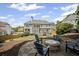 Backyard features stone fire pit and seating with ample space, enhanced by views of a two-story home at 4320 Cody Ct, Cumming, GA 30040