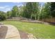 Sprawling backyard with stone pathway leading to a secluded seating area surrounded by lush greenery and a wooden fence at 4320 Cody Ct, Cumming, GA 30040