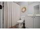Bright bathroom with a white patterned shower curtain, and a decorative sunburst mirror over a white vanity at 4320 Cody Ct, Cumming, GA 30040