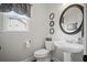 Powder room with pedestal sink, toilet, mirror, and window with curtains at 4320 Cody Ct, Cumming, GA 30040