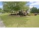 Beautifully landscaped yard with mature trees, stone retaining wall, and lush green lawn at 4320 Cody Ct, Cumming, GA 30040