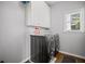 Gray laundry room with front loading washer and dryer and white storage cabinet at 4320 Cody Ct, Cumming, GA 30040