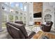 Spacious living room with large windows, stone fireplace, and comfortable leather seating at 4320 Cody Ct, Cumming, GA 30040