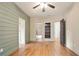 This bedroom offers hardwood floors, shiplap accent wall, built-in shelving, ensuite bathroom, and ceiling fan at 103 Millstone Way, Canton, GA 30115