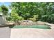 A backyard pool features a captivating rock waterfall, creating a serene oasis surrounded by lush trees at 103 Millstone Way, Canton, GA 30115
