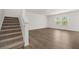 Spacious room with hardwood floors and staircase access to upper level at 1204 Arnhem Dr, Hampton, GA 30228