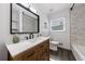 Bright bathroom with wood vanity, white countertop, a large mirror, and a tiled shower at 1600 Donna Sw St, Mableton, GA 30126
