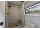 Modern bathroom features a shower with marble tile, pebble floor, and a black shower head at 1600 Donna Sw St, Mableton, GA 30126