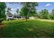 Sprawling front yard featuring a charming white home with a manicured lawn and mature trees at 1600 Donna Sw St, Mableton, GA 30126