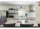 Charming kitchen features white cabinets, open shelving, stainless steel appliances, and a farmhouse sink at 1600 Donna Sw St, Mableton, GA 30126