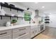 Modern kitchen with white cabinets, farmhouse sink, stainless steel appliances, and black hardware and floating shelves at 1600 Donna Sw St, Mableton, GA 30126
