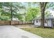Backyard with wood fence, mature trees, level lawn, and concrete driveway at 2056 Hosea L Williams Ne Dr, Atlanta, GA 30317