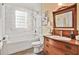 Charming bathroom featuring a vintage vanity, marble tiled walls, and a window block for natural light at 2056 Hosea L Williams Ne Dr, Atlanta, GA 30317