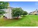Lush backyard featuring mature flowering trees and a small patio area at 8970 Ruel Ln, Suwanee, GA 30024