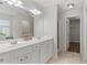 A bright bathroom featuring dual sinks, an oversized mirror and tile floors at 8970 Ruel Ln, Suwanee, GA 30024